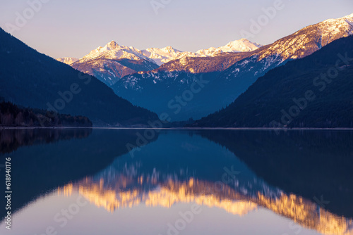 Calm lake with a reflection of a mountain landscape during sunrise © Martin