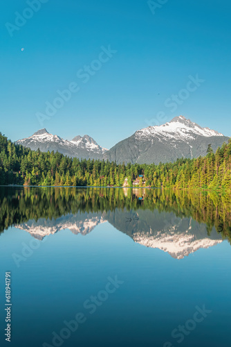 Mirrored reflection of mountains and forest on a calm lake