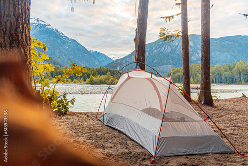 Camping in a tent next to a river and mountains