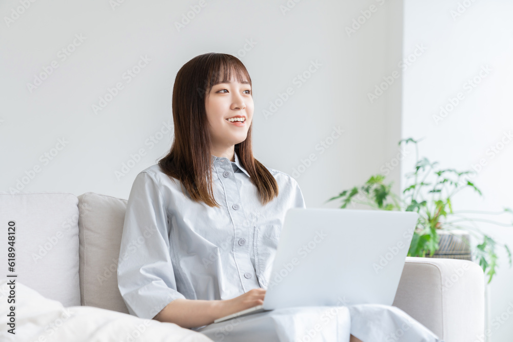 部屋でラップトップコンピューターを見る女性 部屋でラップトップコンピューターを見る女性
