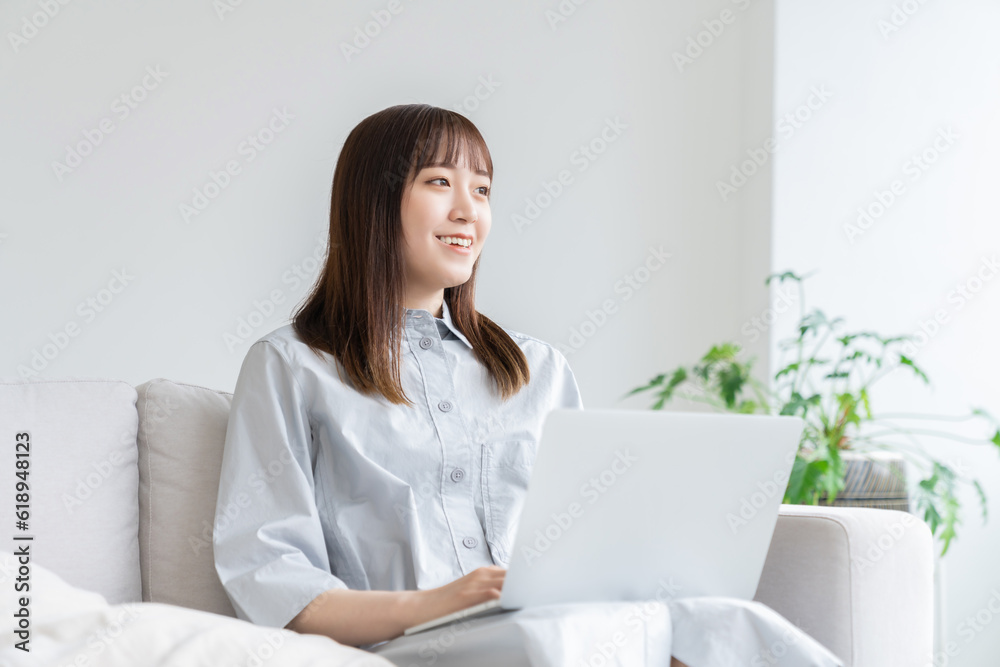 部屋でラップトップコンピューターを見る女性 部屋でラップトップコンピューターを見る女性