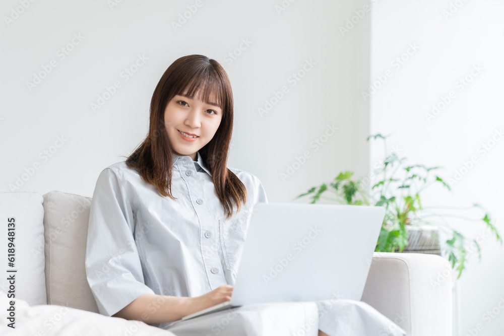 部屋でラップトップコンピューターを見る女性 部屋でラップトップコンピューターを見る女性