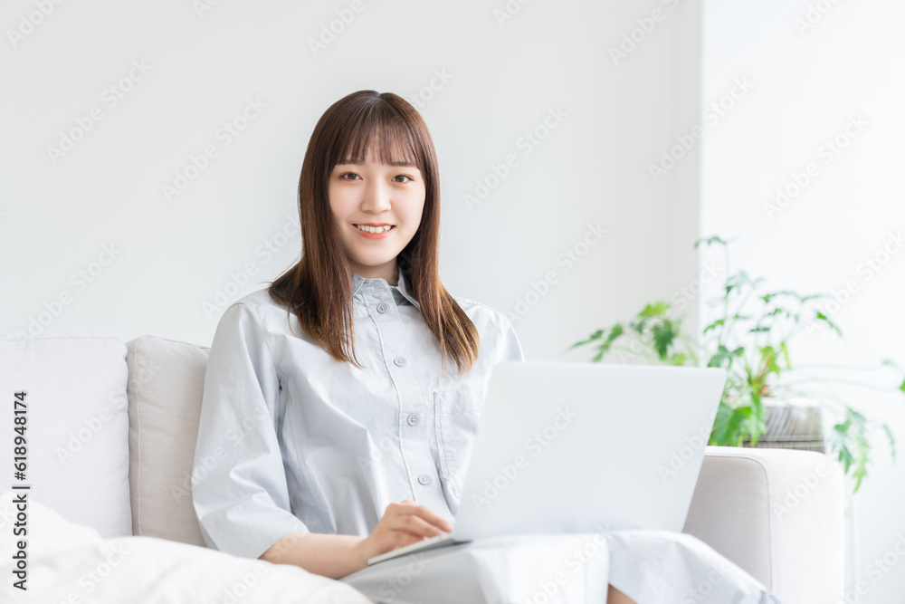部屋でラップトップコンピューターを見る女性 部屋でラップトップコンピューターを見る女性