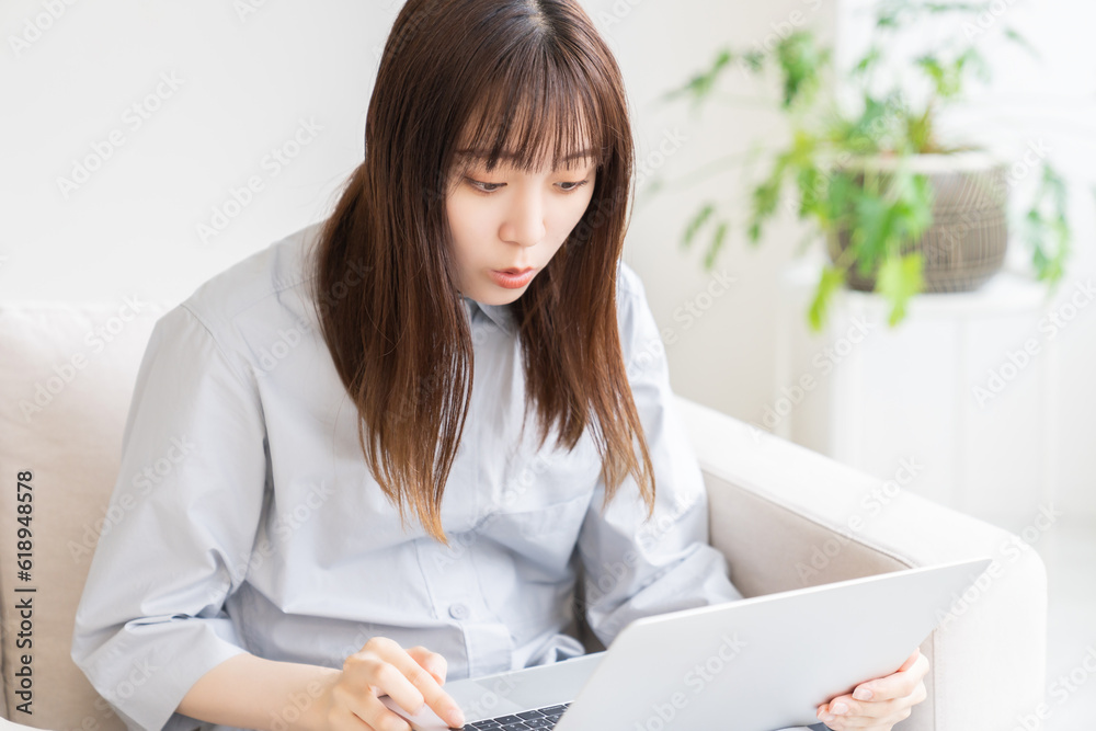 部屋でラップトップコンピューターを見る女性 部屋でラップトップコンピューターを見る女性
