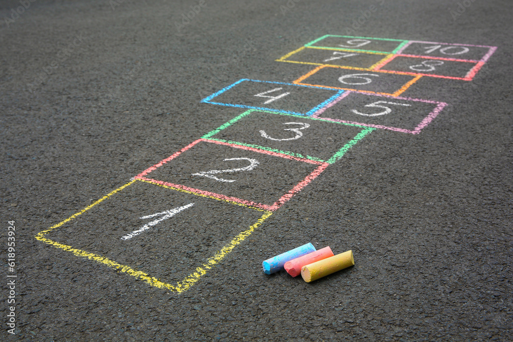 Fototapeta premium Hopscotch drawn with colorful chalk on asphalt outdoors, closeup