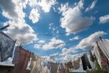 view of laundry fluttering in the breeze with blue sky and fluffy clouds in the background, created with generative ai
