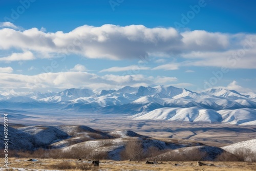snow-capped mountain range in the distance, with rolling clouds and clear blue sky, created with generative ai
