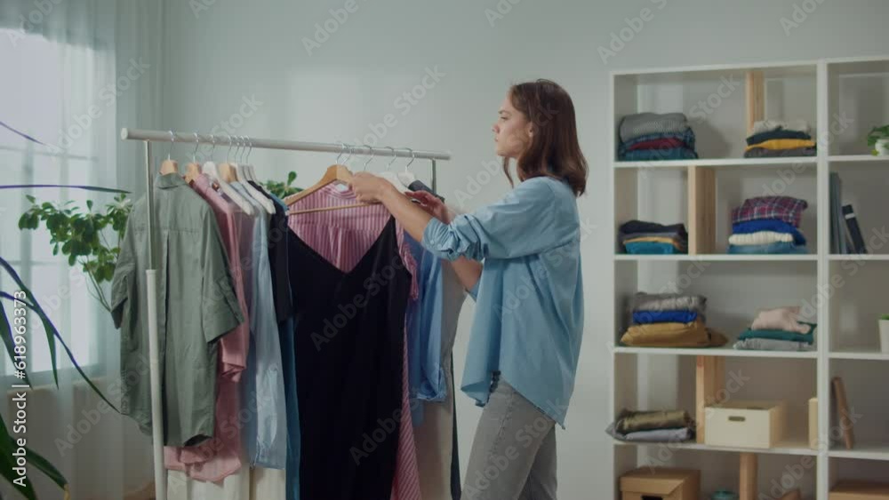 Woman Sorts Through Her Wardrobe to Find the Right Clothes for the Season, Concentrated Woman Reviews her Wardrobe, Selects and Discards Old Clothes, Seasonal Fashion