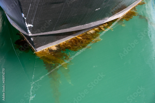 Canvastavla Closeup of black hull of metal boat, seaweed growing on bottom of hull, moored i