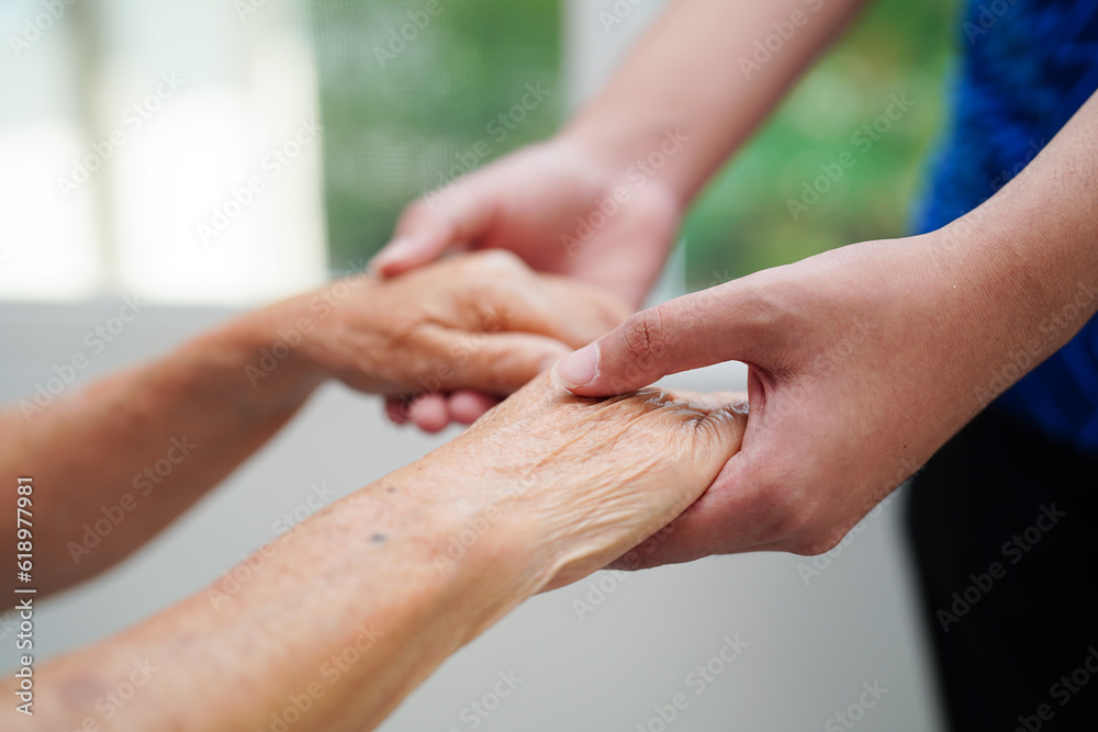 Fototapeta premium Asian young boy holding old grandmother woman hand together with love and care.