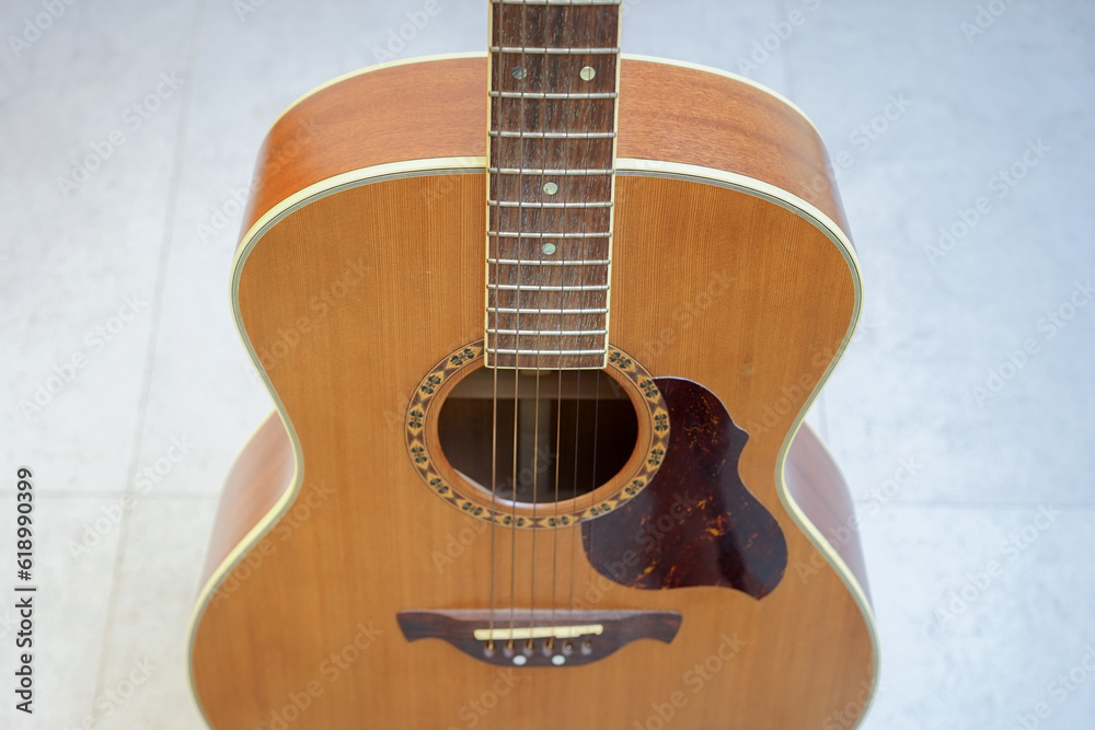 Closeup acoustic guitar on the tile floor