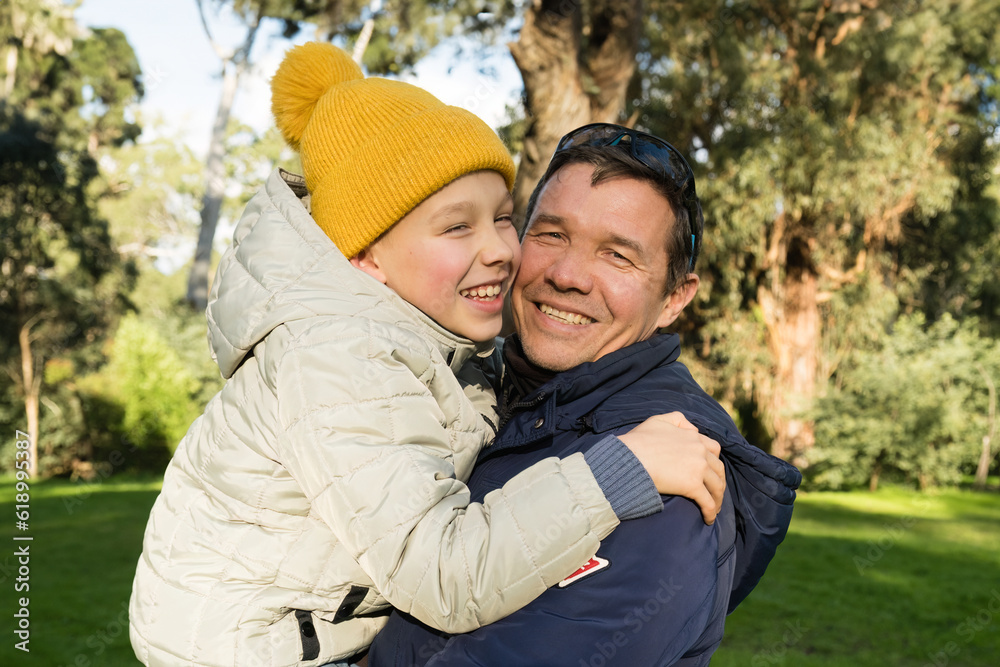 Portrait of smiling son and his dad hugging each other. Connection between son and father. Portrait of smiling son and his dad hugging each other. Connection between son and father.