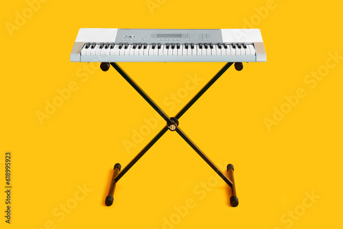 Modern synthesizer on yellow background