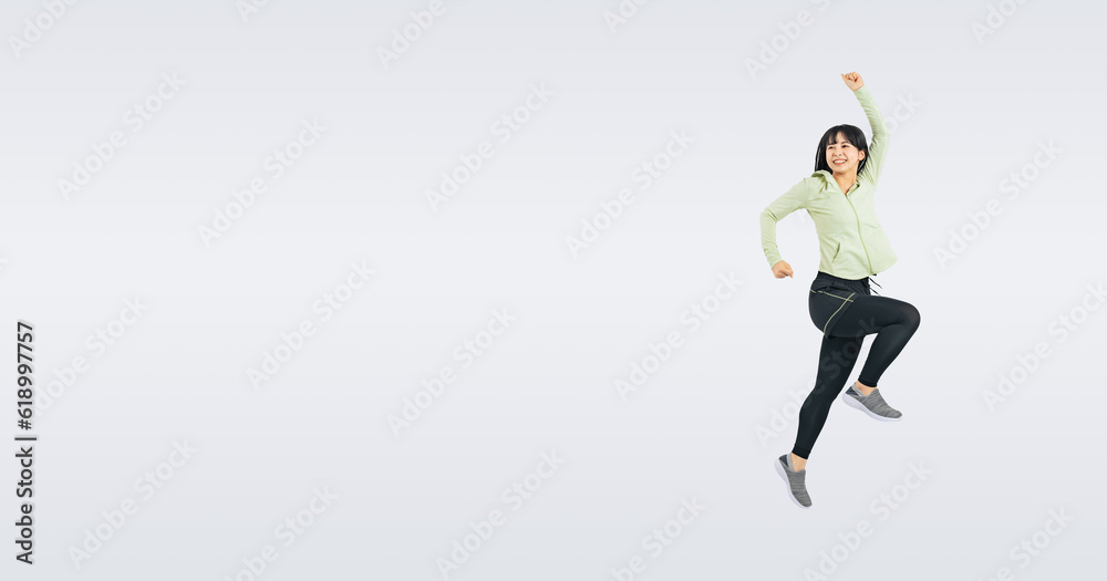 スポーツウェアを着てジャンプする女性　（切り抜き背景透過PNGも販売しております。作成者リンクから「PNG」で検索してください）