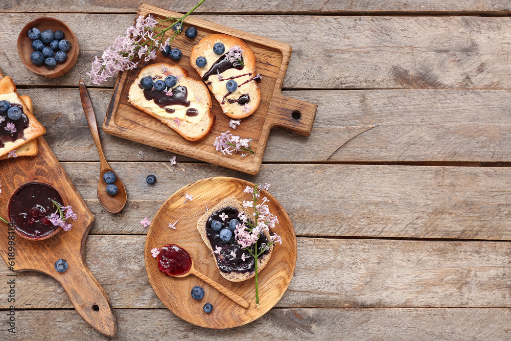 Boards with sweet blueberry jam toasts and flowers on wooden table Boards with sweet blueberry jam toasts and flowers on wooden table
