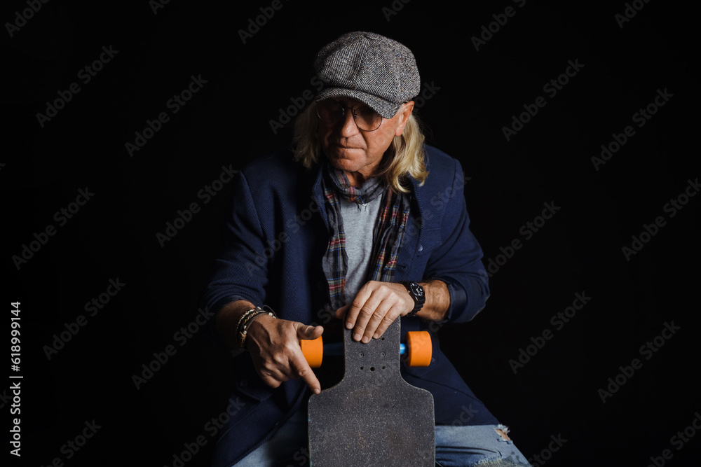 joyful middle aged businessman holding Skateboard. Active old age concept joyful middle aged businessman holding Skateboard. Active old age concept