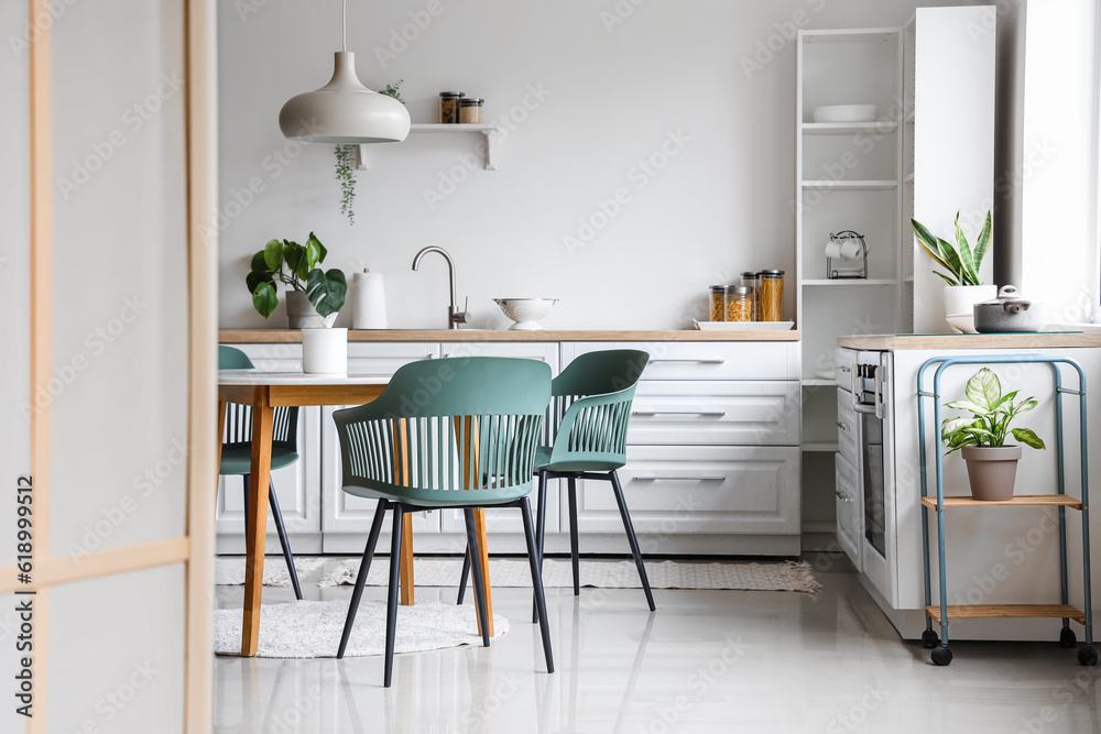 Plagát Interior of light kitchen with dining table and white counters ...