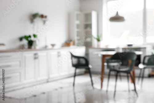 Blurred view of light kitchen with dining table and white counters © Pixel-Shot