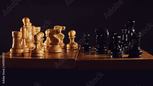 Old chess game with a queen gambit opening on a black background, stop motion photo