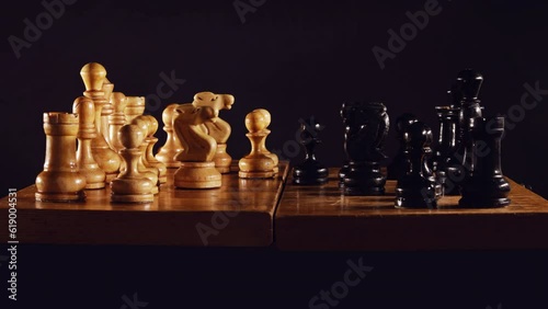 Old chess game with a queen gambit opening on a black background, stop motion