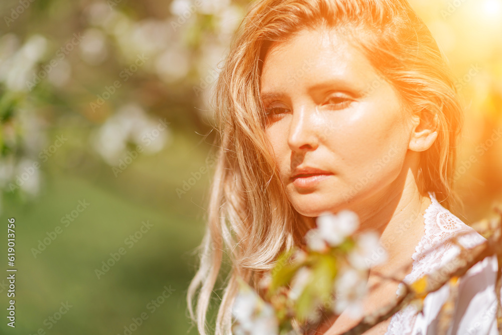 Blond garden. Portrait of a blonde in the park. Happy woman with long blond hair in a blue dress. Blond garden. Portrait of a blonde in the park. Happy woman with long blond hair in a blue dress.