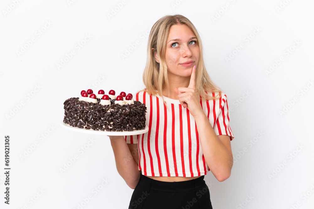 Young caucasian woman holding birthday cake isolated on white background having doubts and thinking Young caucasian woman holding birthday cake isolated on white background having doubts and thinking