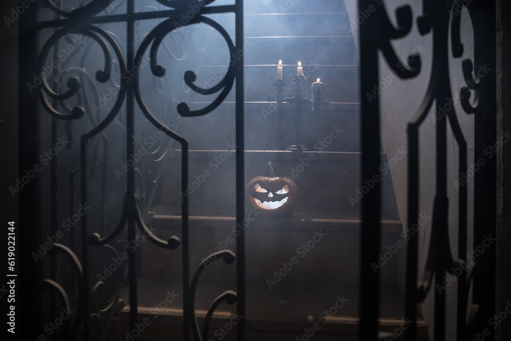 Inside of old creepy abandoned mansion. Silhouette of horror ghost standing on castle stairs to the basement. Spooky dungeon stone stairs in old castle with light. Horror Halloween concept Inside of old creepy abandoned mansion. Silhouette of horror ghost standing on castle stairs to the basement. Spooky dungeon stone stairs in old castle with light. Horror Halloween concept