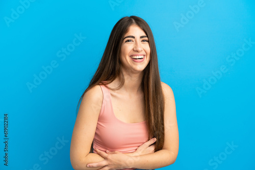 Young caucasian woman isolated on blue background smiling a lot