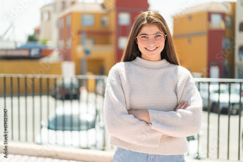 Young pretty caucasian woman with glasses at outdoors keeping the arms crossed in frontal position Free Download Young pretty caucasian woman with glasses at outdoors keeping the arms crossed in frontal position - GFXLoad