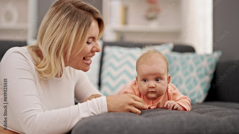 Mother and daughter sitting together touching nose at home Mother and daughter sitting together touching nose at home