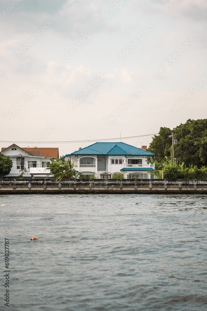 Idyllic blue-roofed house situated near a body of water in Bangkok, Thailand