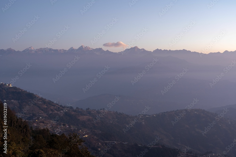 Stunning landscape of a mountain range at sunset with a small town in the foreground