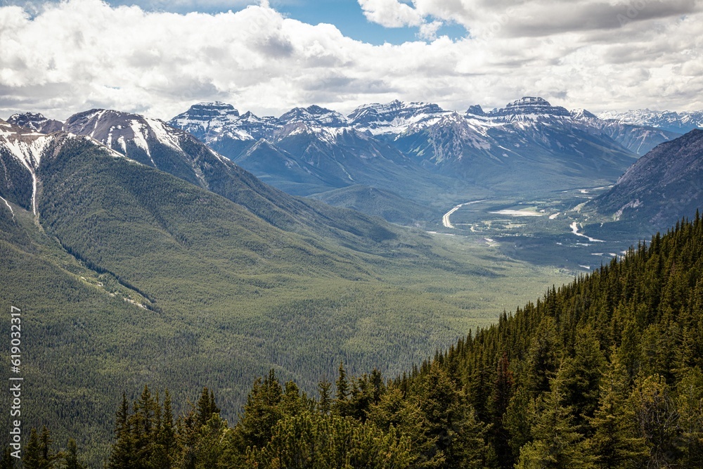 Scenic view of a green valley surrounded by rocky mountains. Banff National Park, Alberta, Canada.