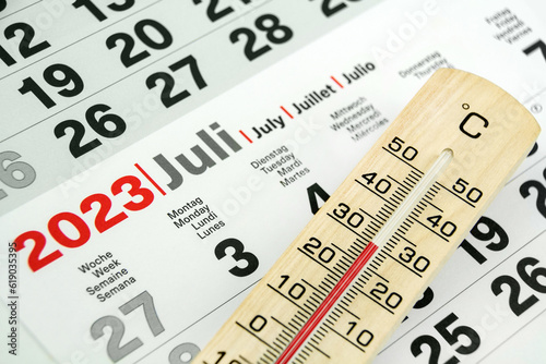 Deutscher Kalender Juli 2023 und Thermometer aus Holz  30 Grad Celsius photo