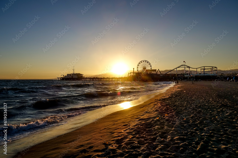 Mesmerizing view of sea waves washing the shore with Ferris wheel on the background, Santa Monica