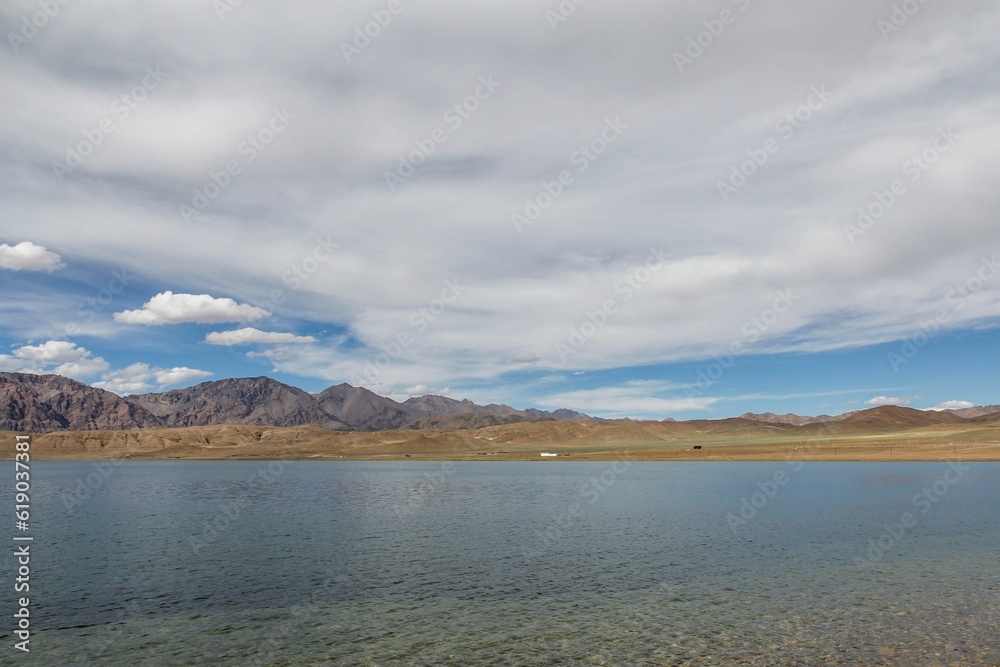 Tranquil scene of serenity and beauty, a body of water with a vast array of clouds in the sky