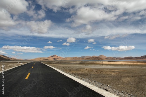 Aerial view of road through desert surrounded by hills