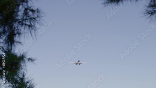 Commercial aircraft slowly approaching airport and really windy condition with a clear blue sky in between the trees las Vegas Nevada USA 4K high-quality footage
