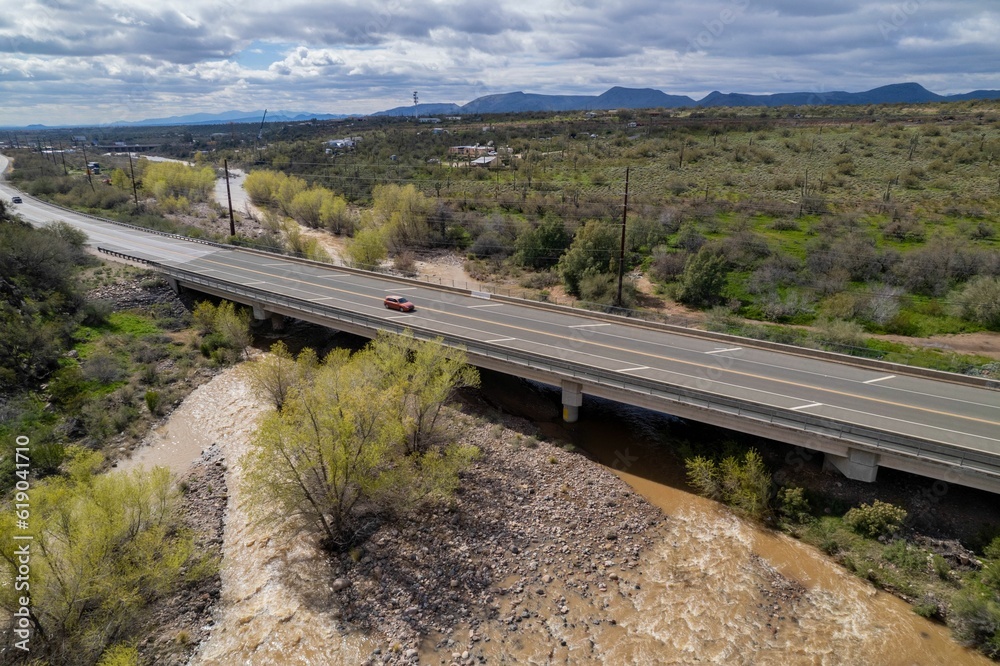 Shot of a picturesque bridge situated in a lush green landscape over a river in Arizona