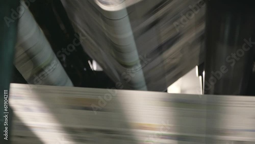 Newspapers rolling on printing press.
