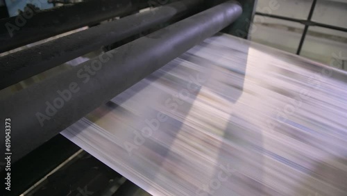 Newspapers rolling on printing press.
 photo