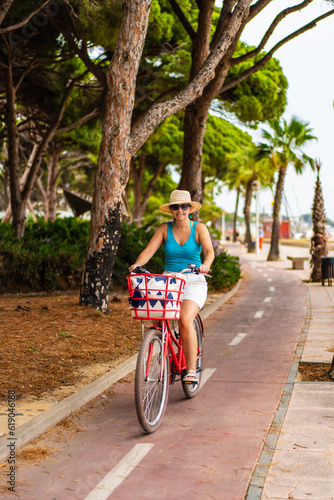 Woman riding bicycle on seaside boulevard 