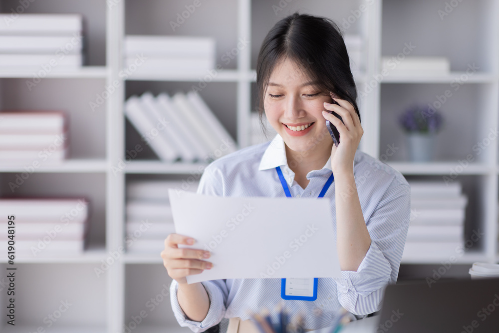 Cheerful business Asian woman employees making telephone call share good news about project working in office workplace, asian business finance concept. Cheerful business Asian woman employees making telephone call share good news about project working in office workplace, asian business finance concept.