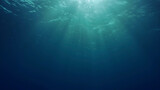 View of sun light from blue abyss, slow motion. Light filters down through blue water. Underwater sun rays in depth ocean. Underwater sun light shine under deep water with ripples on waves surface