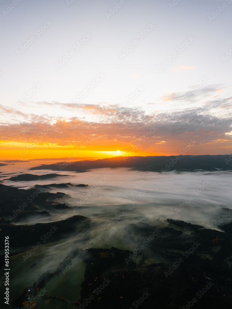Sunny sunrise in autumn mountains. Mountains in a fog illuminated by rising sun. Autumn landscape with vivid sunlight. Sunny sunrise in autumn mountains. Mountains in a fog illuminated by rising sun. Autumn landscape with vivid sunlight.