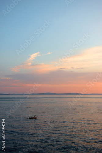 Small fishing boat illuminated by warm golden hour light. Beautiful sunset in Stobrec, small town near Split, Croatia.