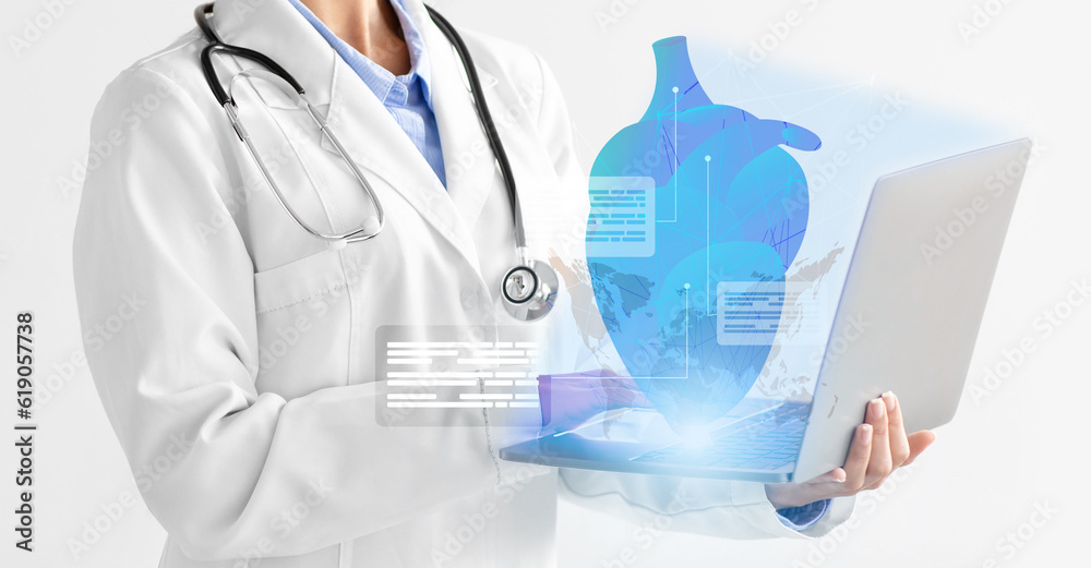 Cropped of woman doctor using laptop, examining human heart, collage Cropped of woman doctor using laptop, examining human heart, collage