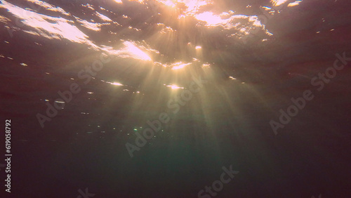 Evening sunlight creates beautiful veil, consisting of sunlight at sunset. Underwater ocean waves oscillate and flow with rays of light at sundown, Red sea, Egypt