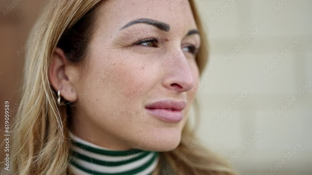 Young beautiful hispanic woman standing with serious expression looking to the side at street Young beautiful hispanic woman standing with serious expression looking to the side at street