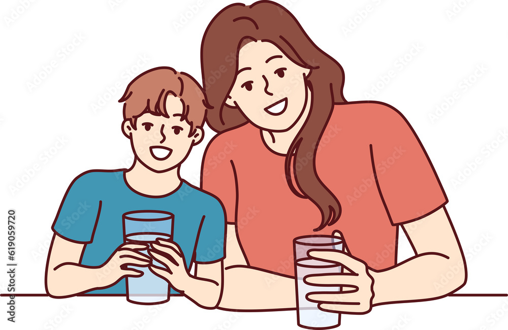 Happy mom and son drink water from transparent glasses and smile enjoying clean refreshing beverage Happy mom and son drink water from transparent glasses and smile enjoying clean refreshing beverage